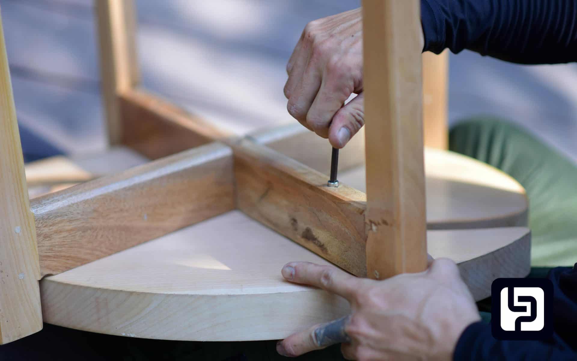Hands assembling a wooden table