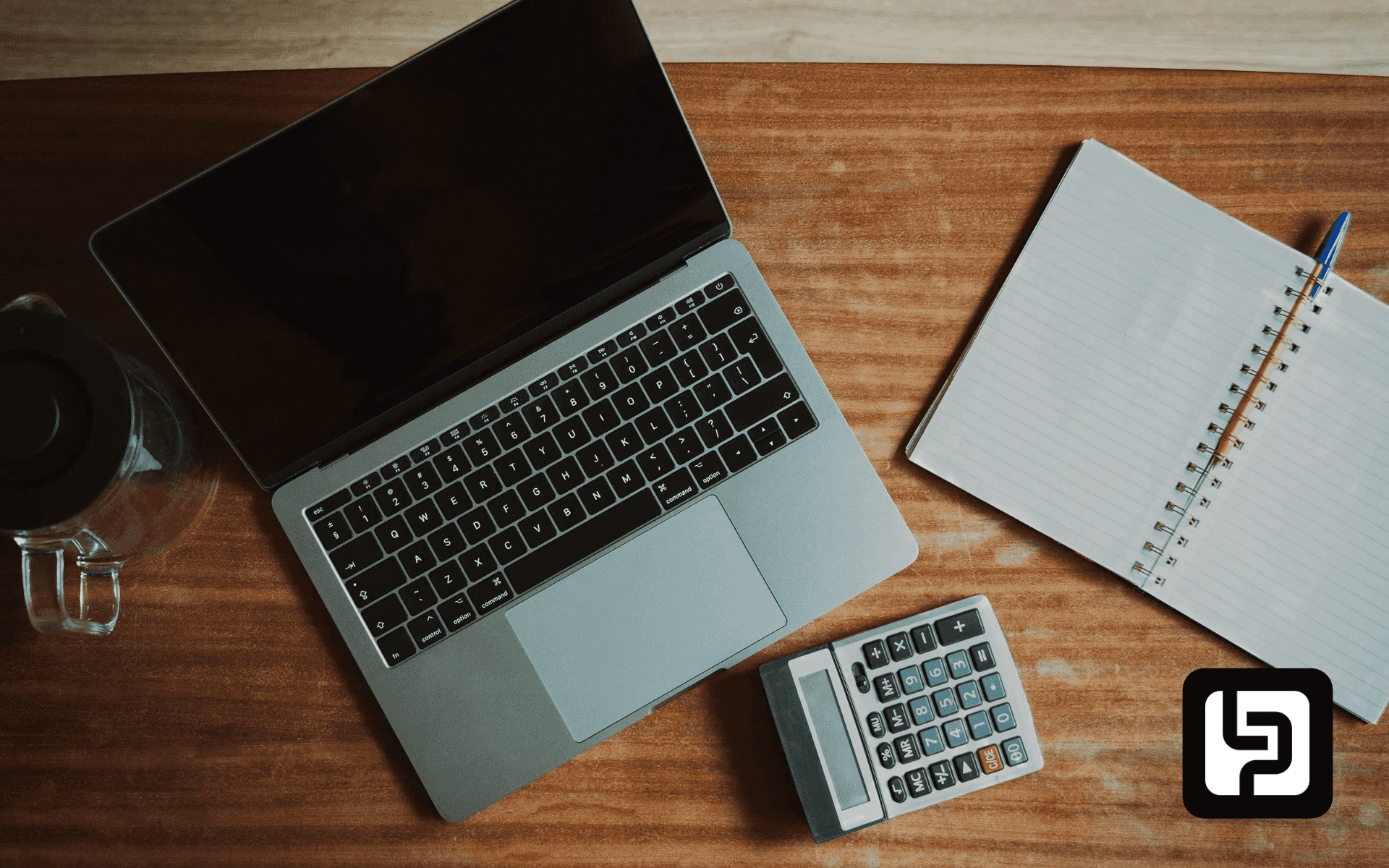 Laptop, calculator and notebook on a desk
